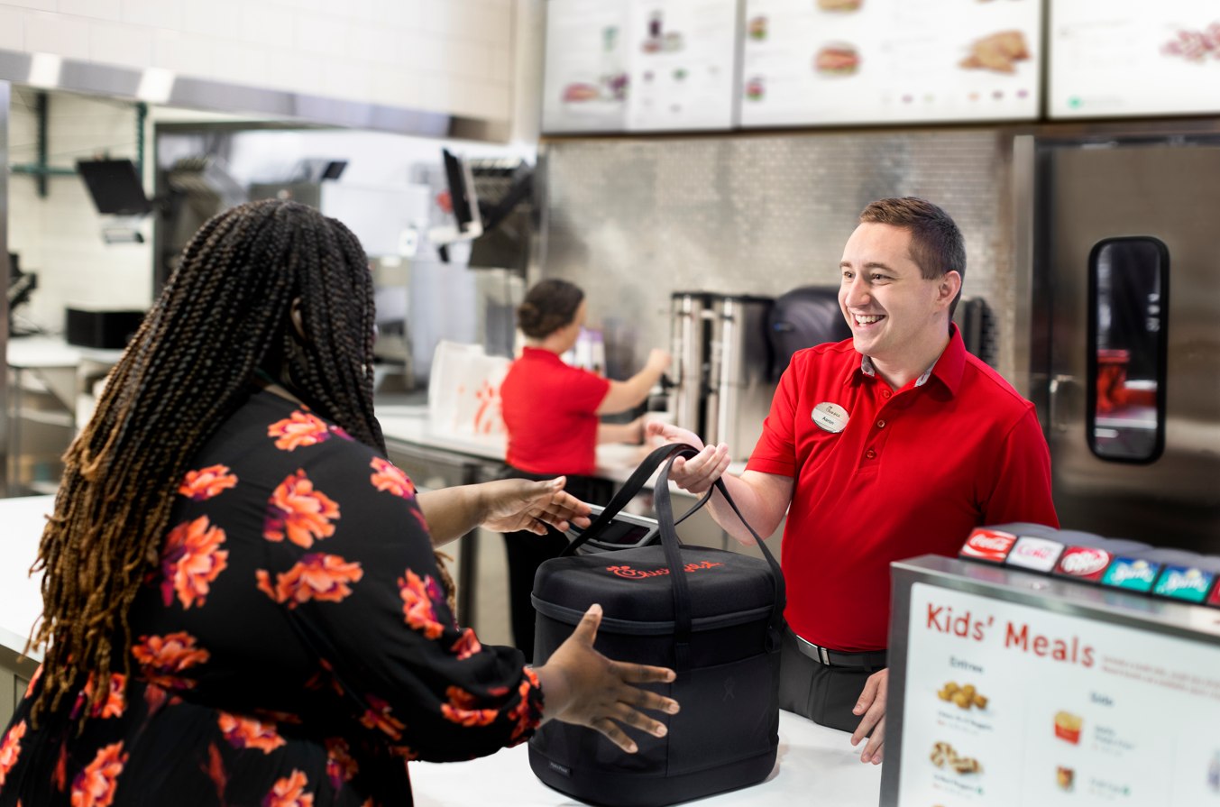 Chick-fil-A Team Member hands packaged surplus food to a non-profit recipient through the Chick-fil-A Shared Table programme.