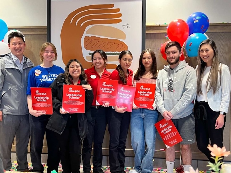 Susanna Choe (right) and her husband, Philip (left), surprise Chick‑fil‑A Serramonte Team Members with scholarships.